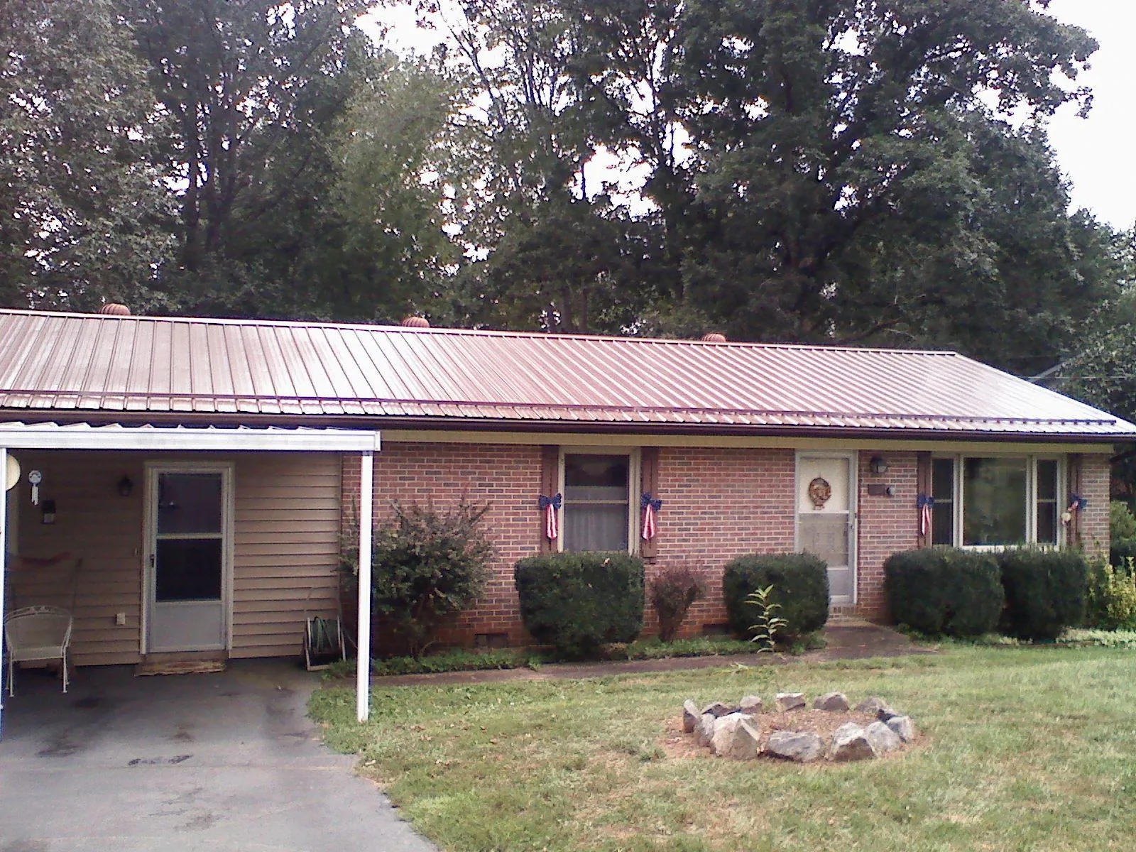 Bronze metal roof and carport on a brick ranch home — Roof Repair work by our crew in Rockledge